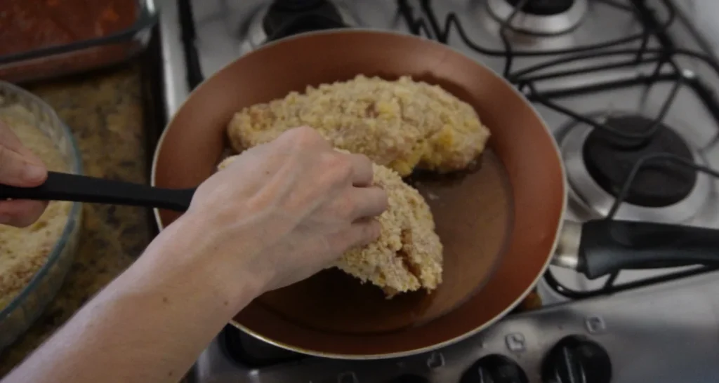 fritando filés de frango empanados