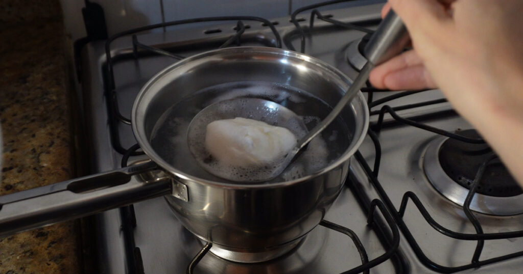 testando receitas ovo pochê com redemoinho na água sendo retirado da água