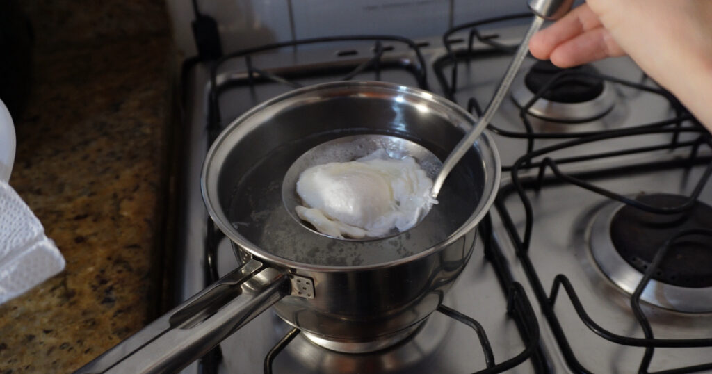 testando receitas ovo pochê sendo retirado da água