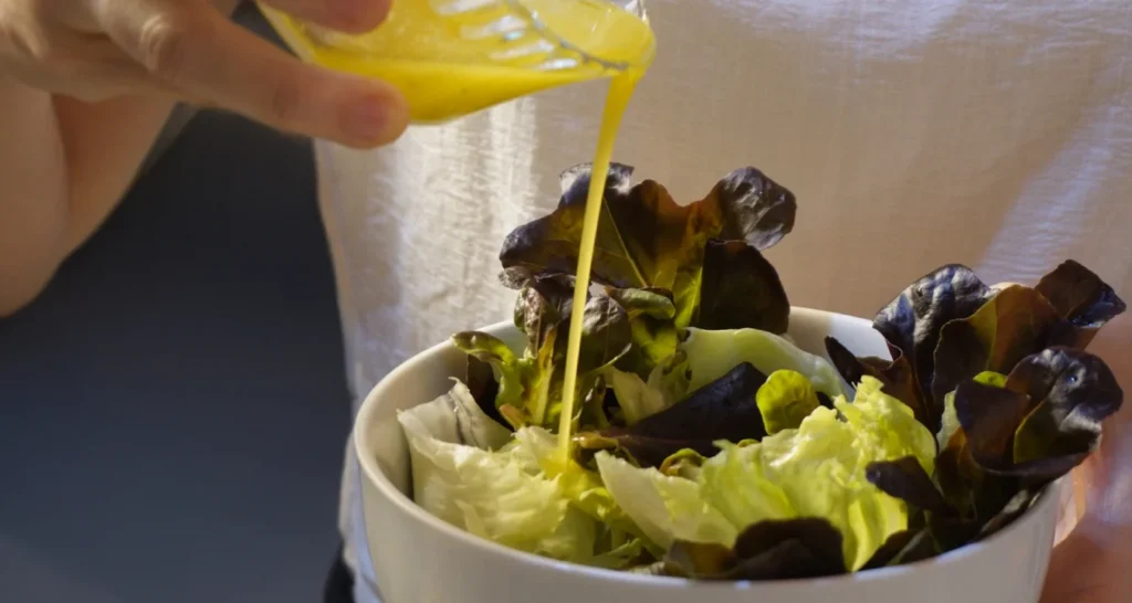 temperando uma salada de folhas verdes com vinagrete da culinária francesa clássica
