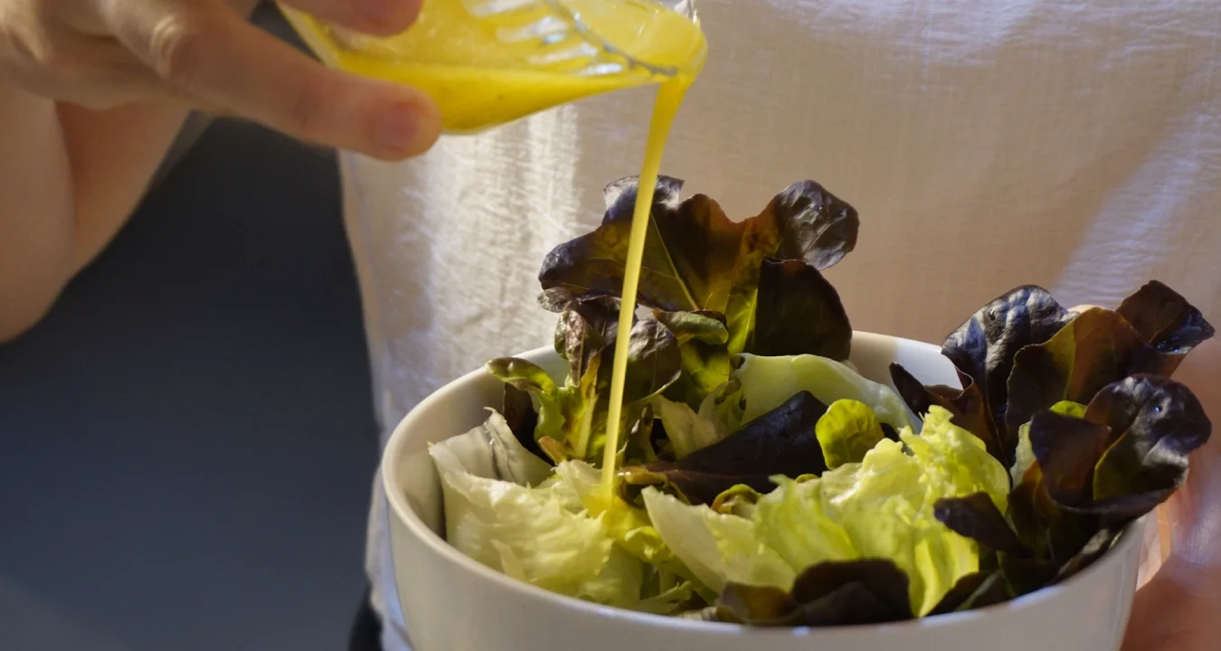 temperando uma salada de folhas verdes com vinagrete da culinária francesa clássica